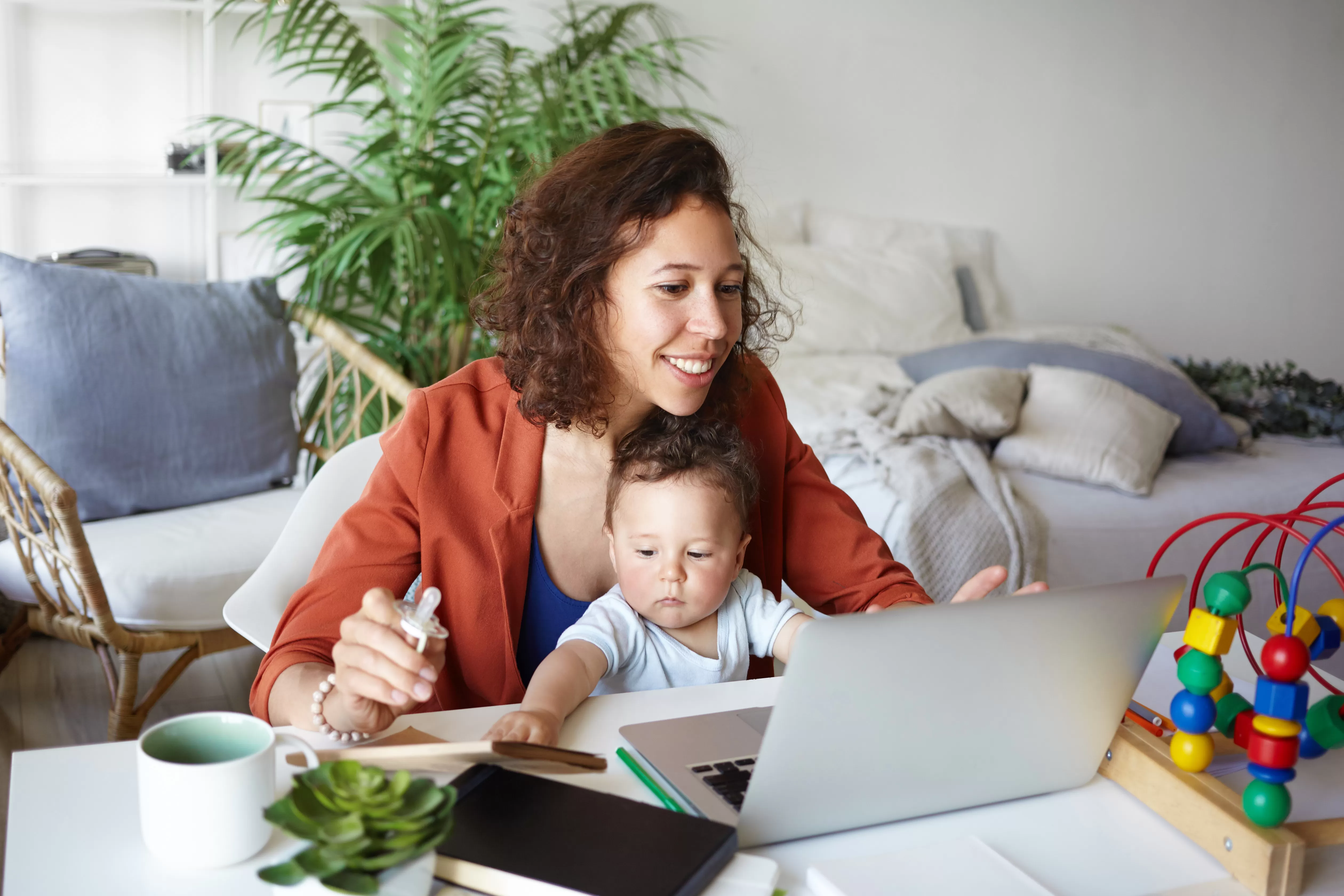 Woman sitting in front of a computer with her baby