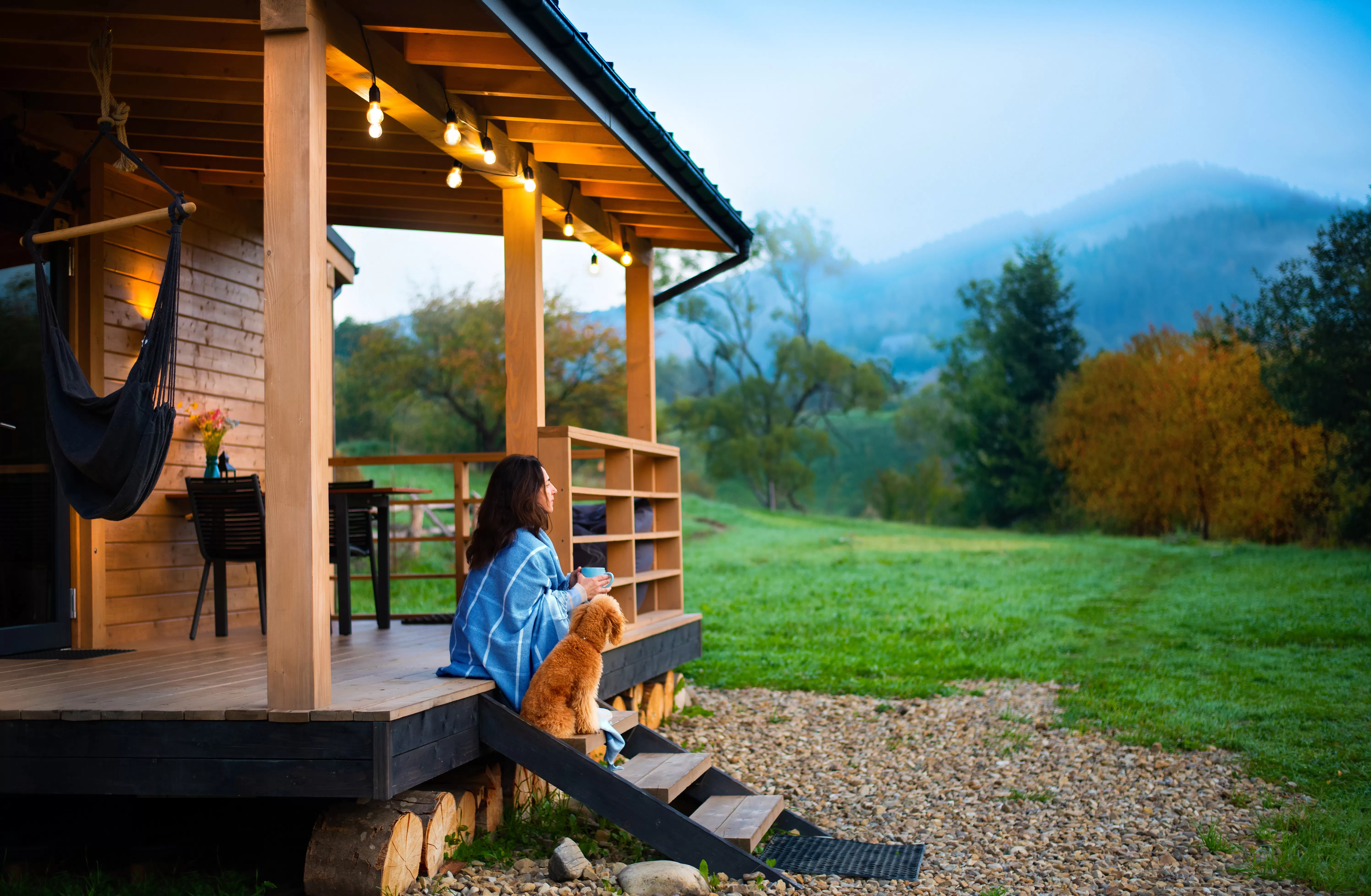 woman and her dog resting on the front steps of a cabin