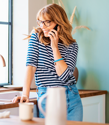 Woman using phone banking in kitchen