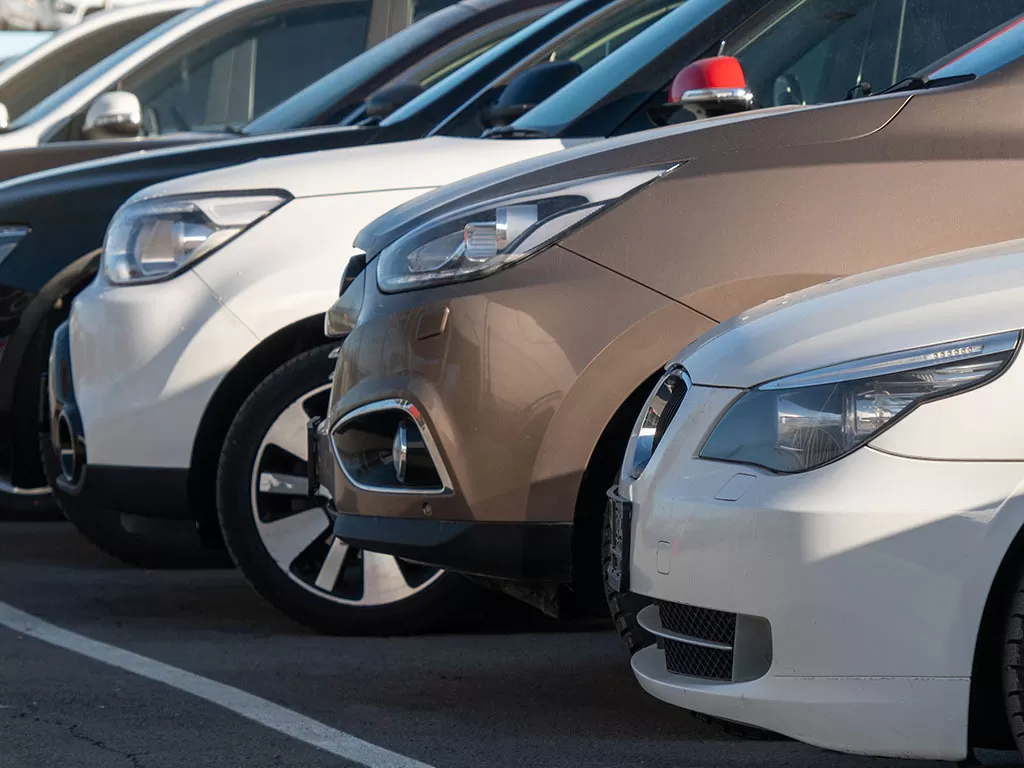 A row of vehicles in a car dealership lot.